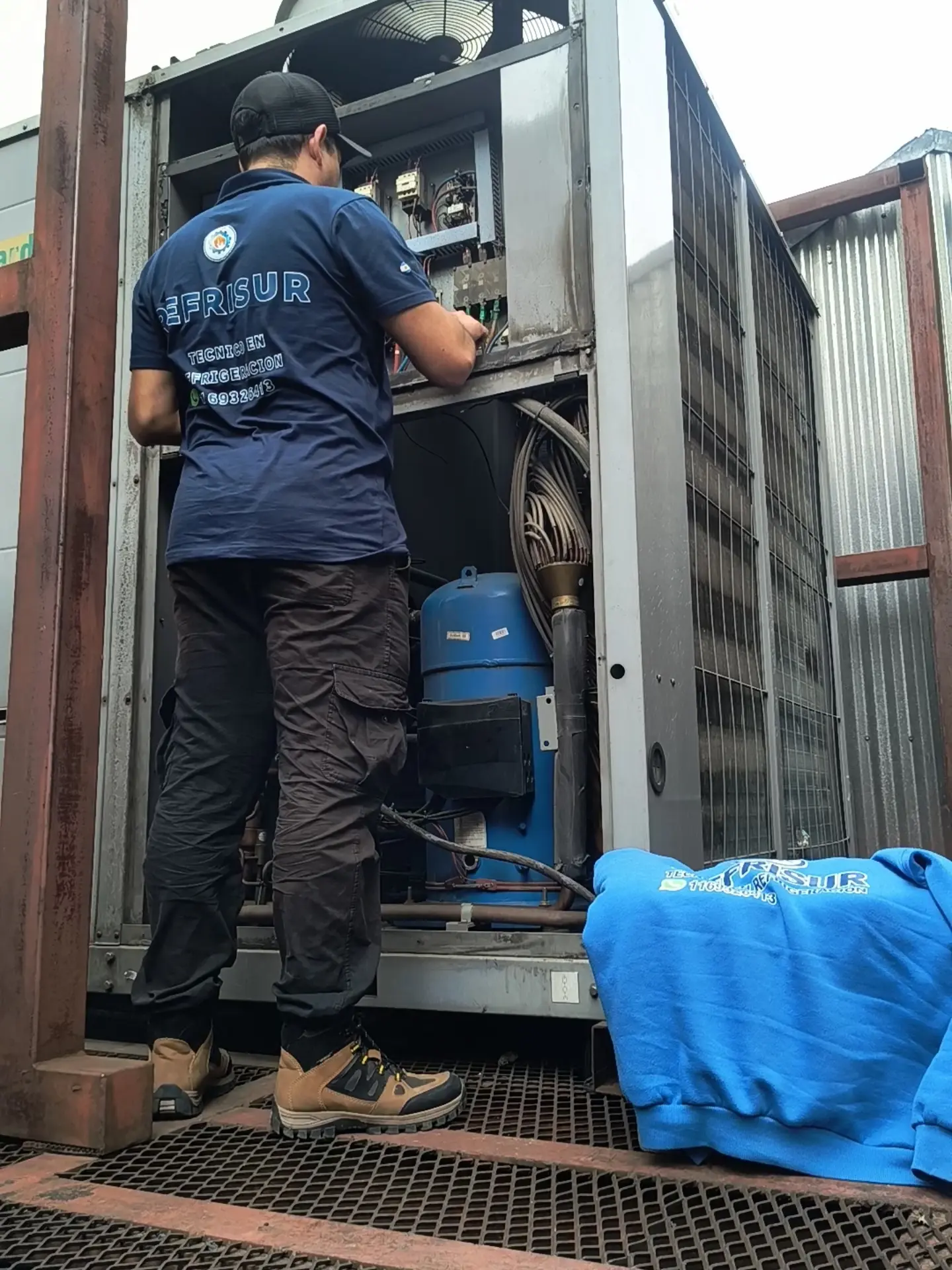 Técnico de Refrisur trabajando en unidad de HVAC industrial